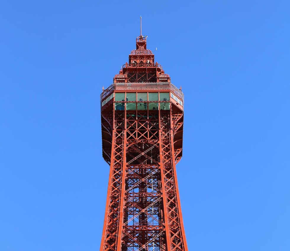 Red iron tower against a clear blue sky.
