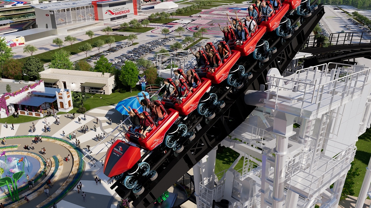 Red roller coaster climbing steep track at Cotaland amusement park, people with raised arms.