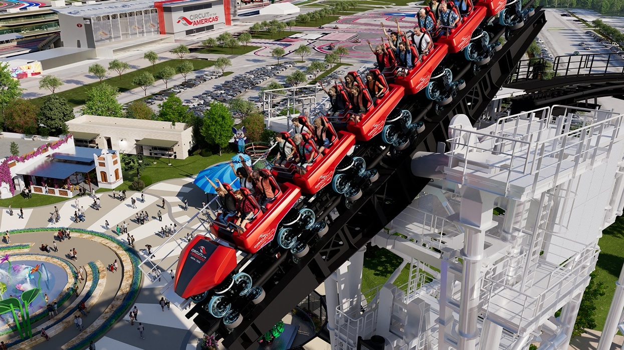 Red roller coaster climbing steep track at Cotaland amusement park, people with raised arms.