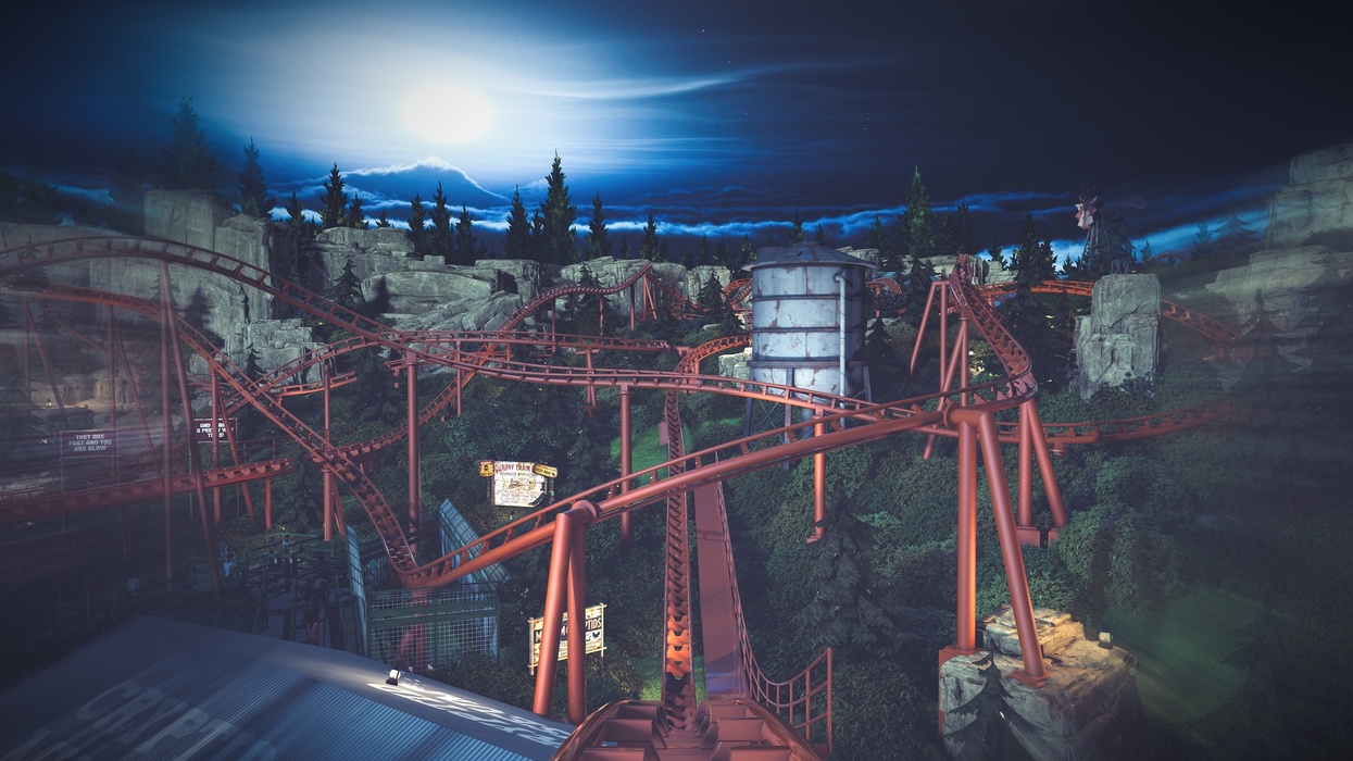Red roller coaster track of Werewolf Gorge at Six Flags Fiesta Texas winding through a forested area under a moonlit, cloudy night sky.