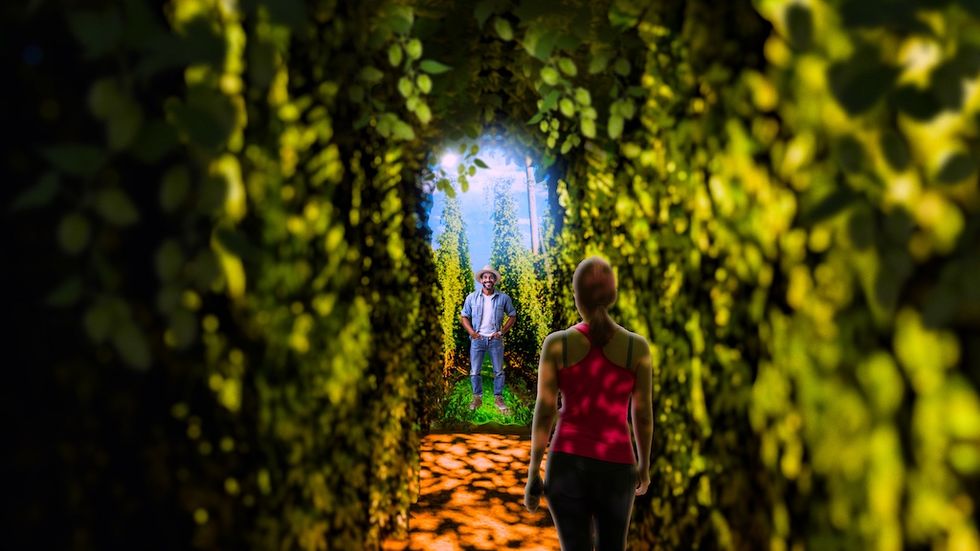 Rendering for Balashi Beer Experience shows two people in a lush, green plant hops tunnel under dappled sunlight.