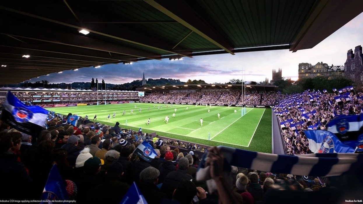 Rendering of crowd in proposed Bath Rugby stadium watching a rugby match at sunset, waving blue and white flags.