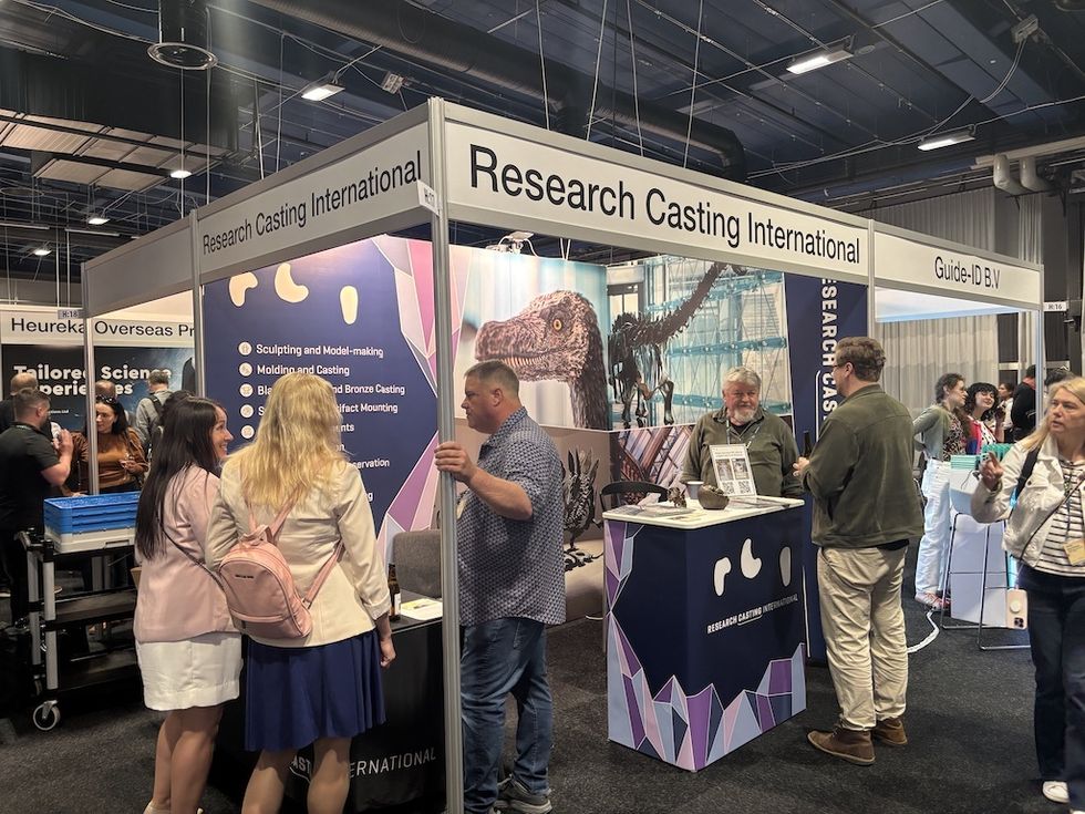 Research Casting International booth with visitors at a busy exhibition hall.