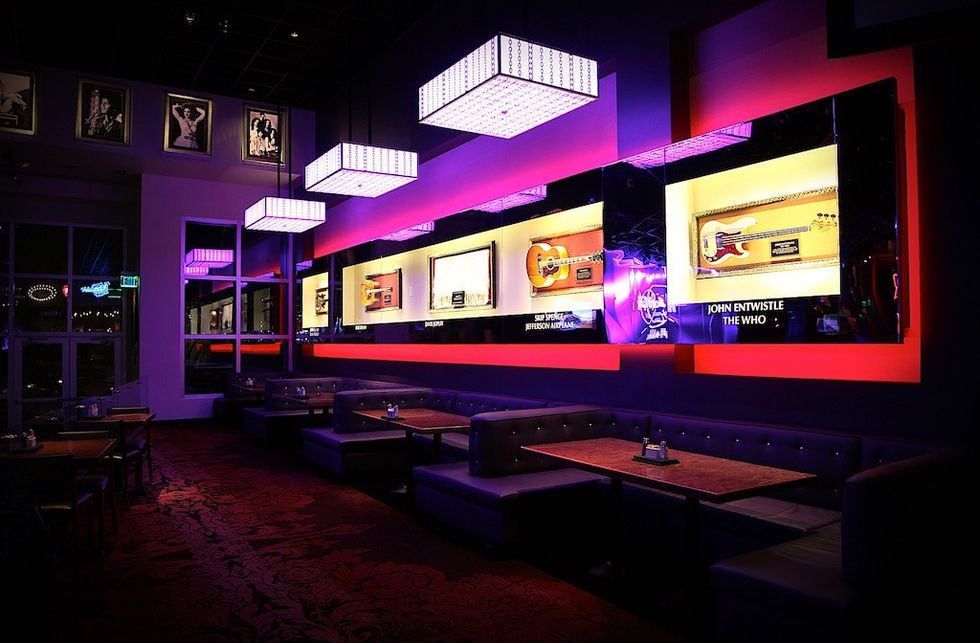 Restaurant interior with neon-lit guitar displays and booth seating.