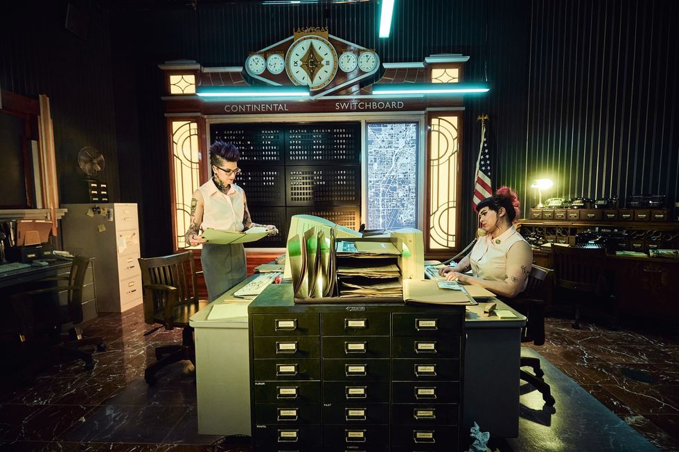 Retro switchboard room with two operators working at desks.