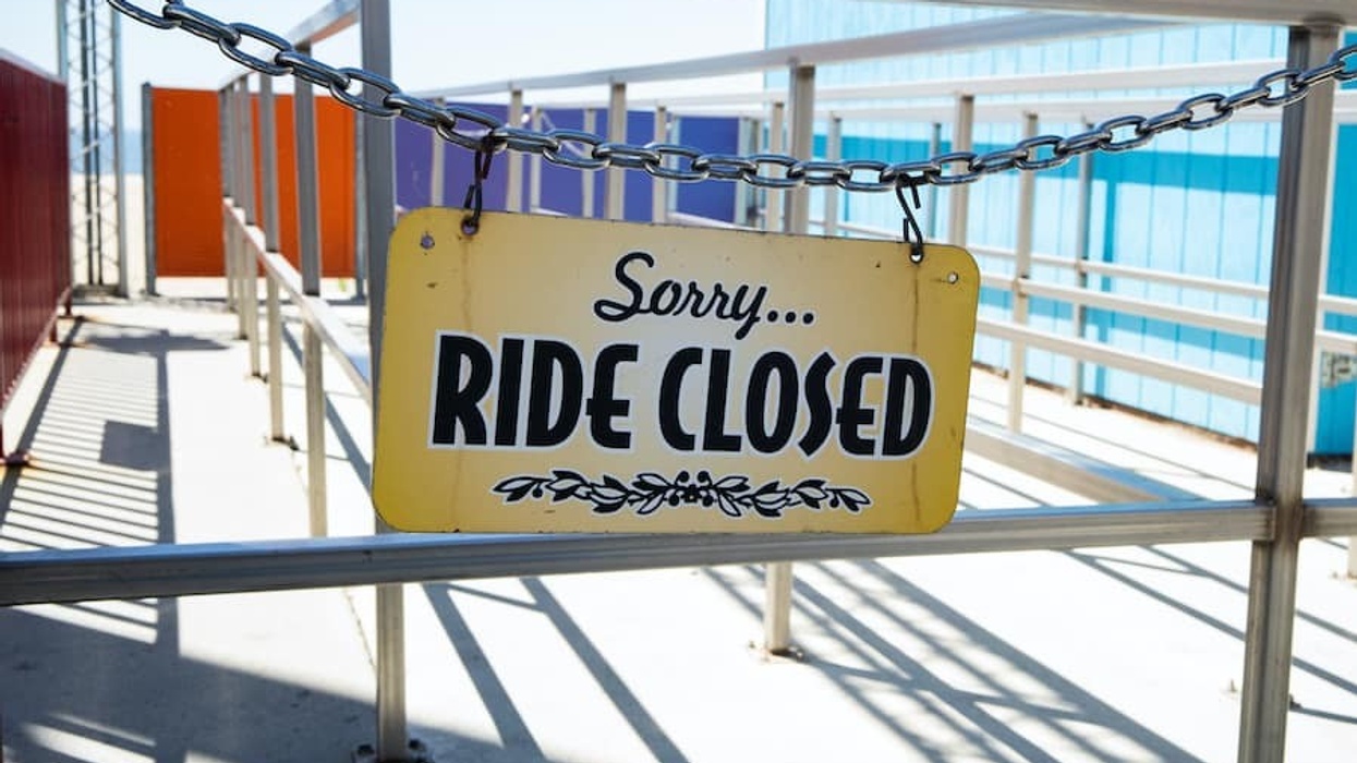 ride closed sign hanging on empty amusement park ride