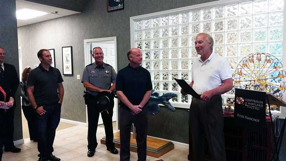 Ride-Entertainment-CEO-Ed-Hiller-black-shirt-accepts-the-Maryland Bright Lights Award from-Maryland-Comptroller-Peter-Franchot