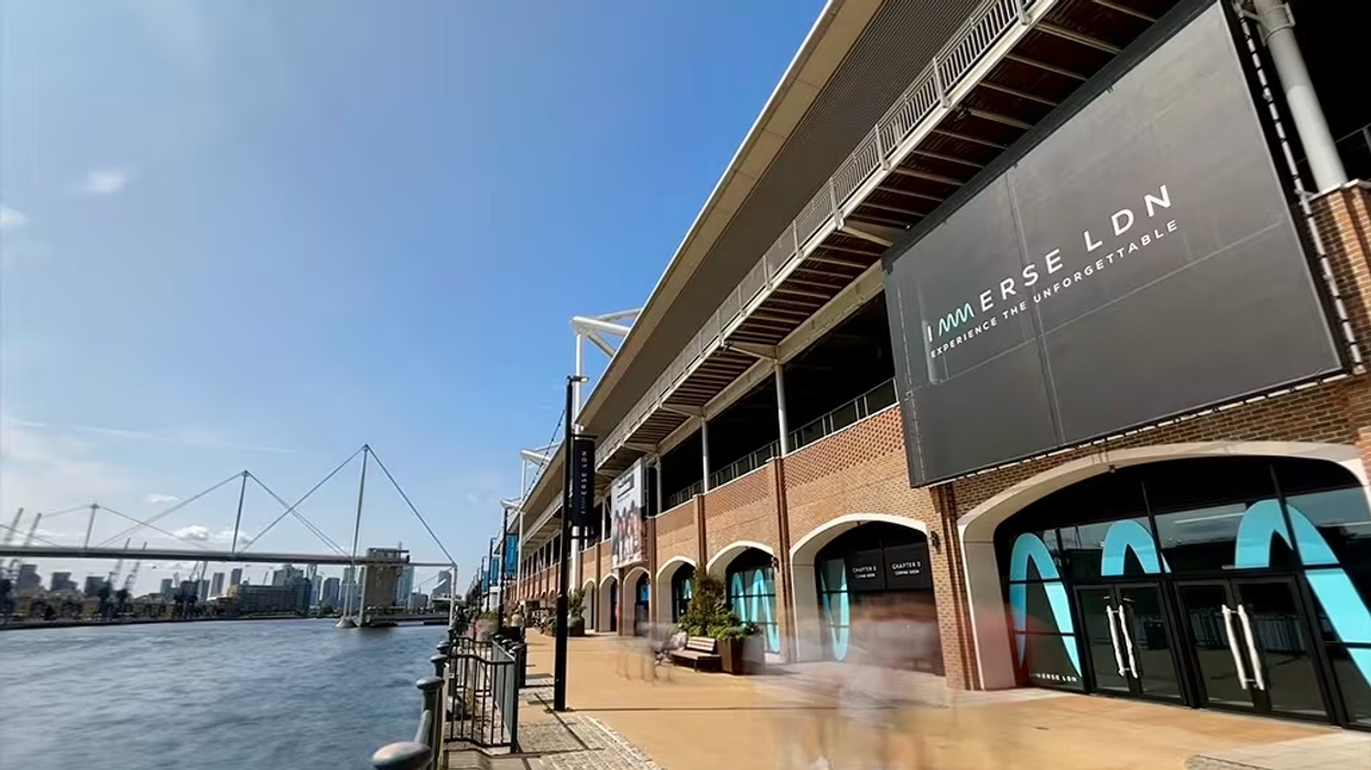 Riverside building with large "IMMERSE LDN" sign, bridge and city skyline visible.
