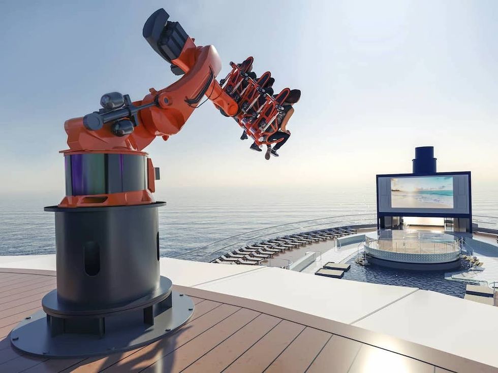 Robotic thrill ride on cruise ship deck with ocean view and outdoor screen.