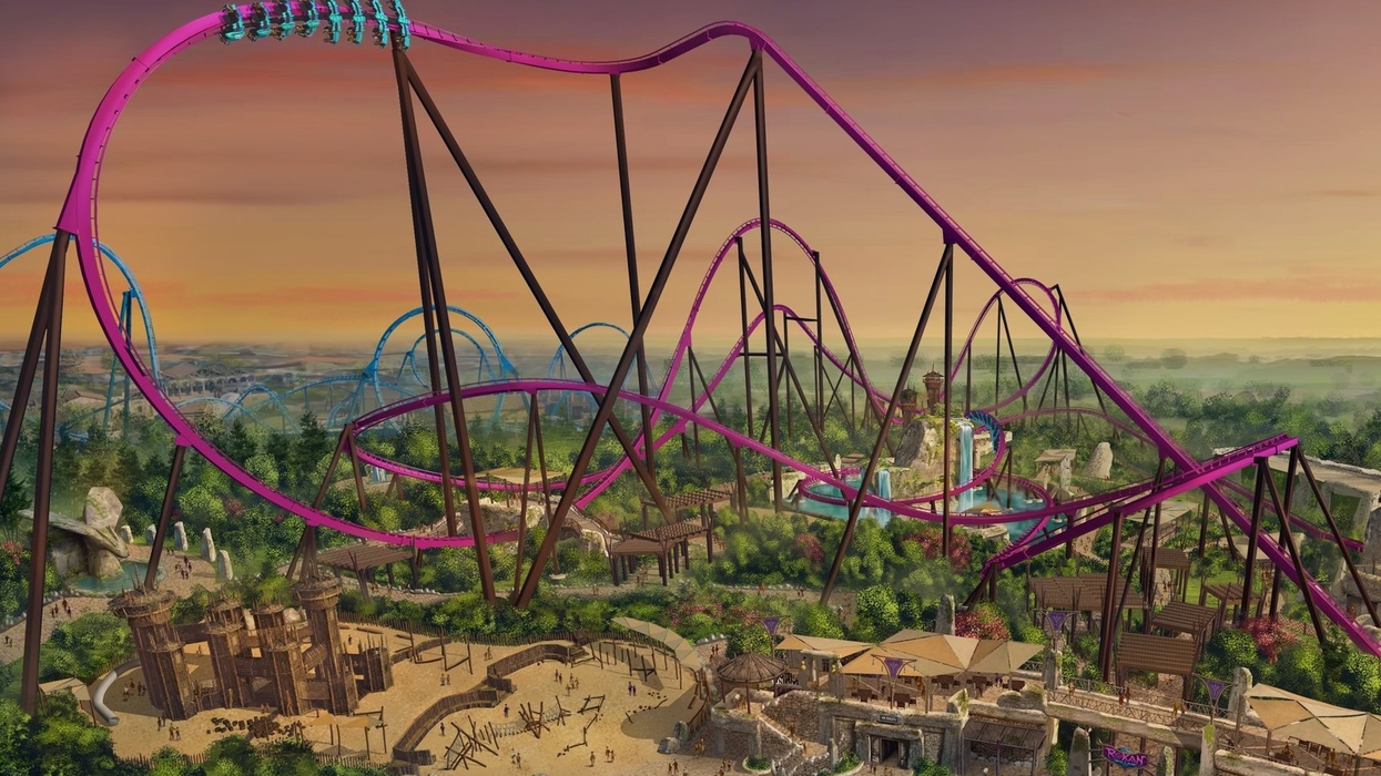 Roller coaster at sunset with purple tracks, surrounded by greenery and theme park attractions.