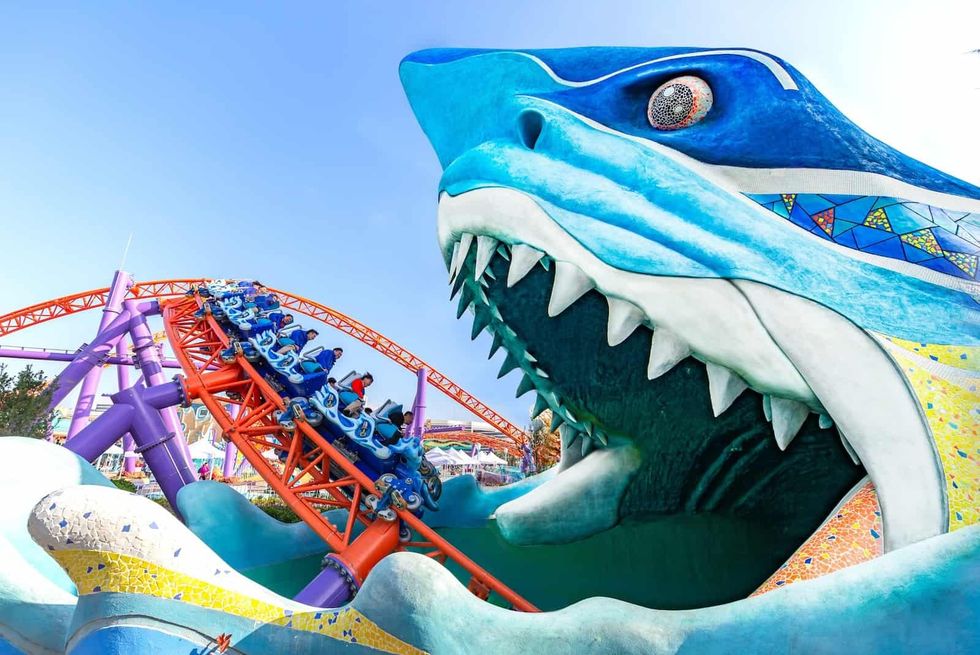 Roller coaster entering giant shark mouth sculpture Shanghai Haichang Ocean Park