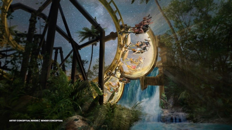 Roller coaster loop at night with riders above a waterfall in a jungle setting.