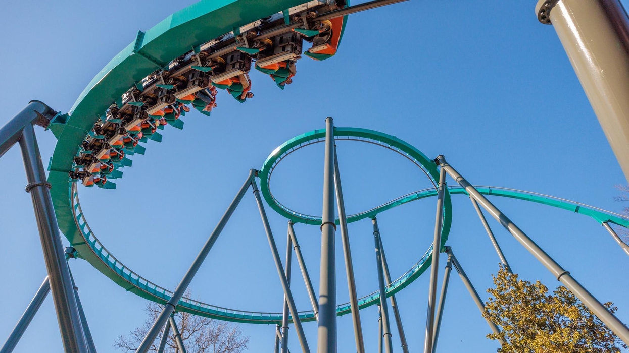 Roller coaster loop with passengers against a clear blue sky at Six Flags Over Georgia