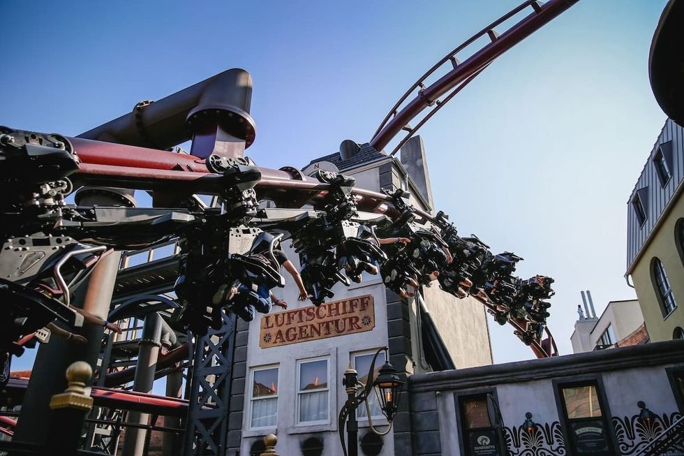 roller coaster riders over building