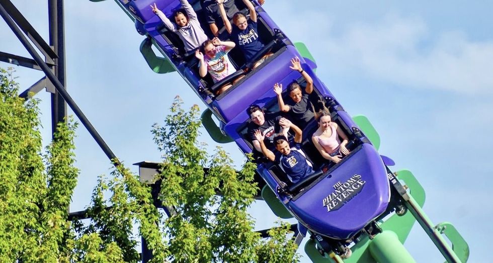 Roller coaster riders with raised hands on "The Phantom's Revenge."