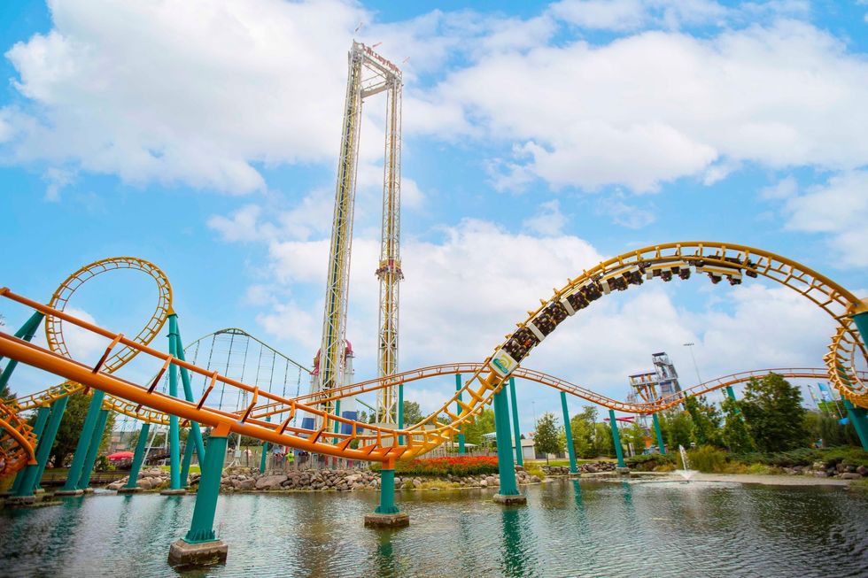 Roller coaster with yellow tracks looping over water at an amusement park called Valleyfair