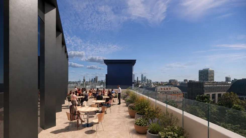 Rooftop terrace with people socializing, city skyline in the background.