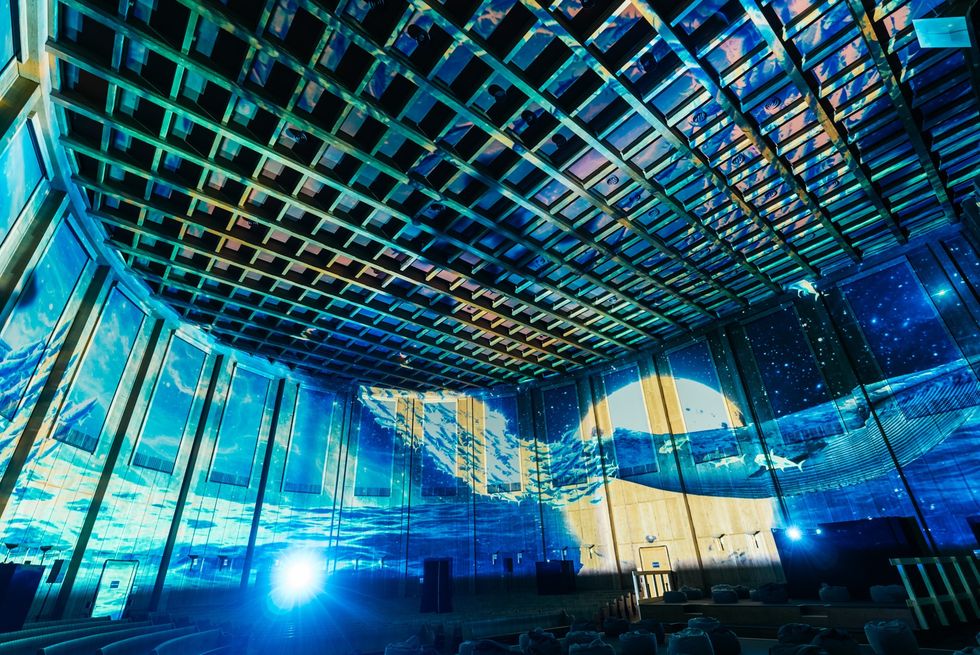 Room with ceiling and walls projecting a vibrant ocean and night sky scene.