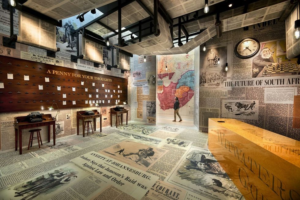 Room with vintage newspapers, typewriters, map, and a "Penny for Your Thoughts" board. The War Rooms at The Story of Emily