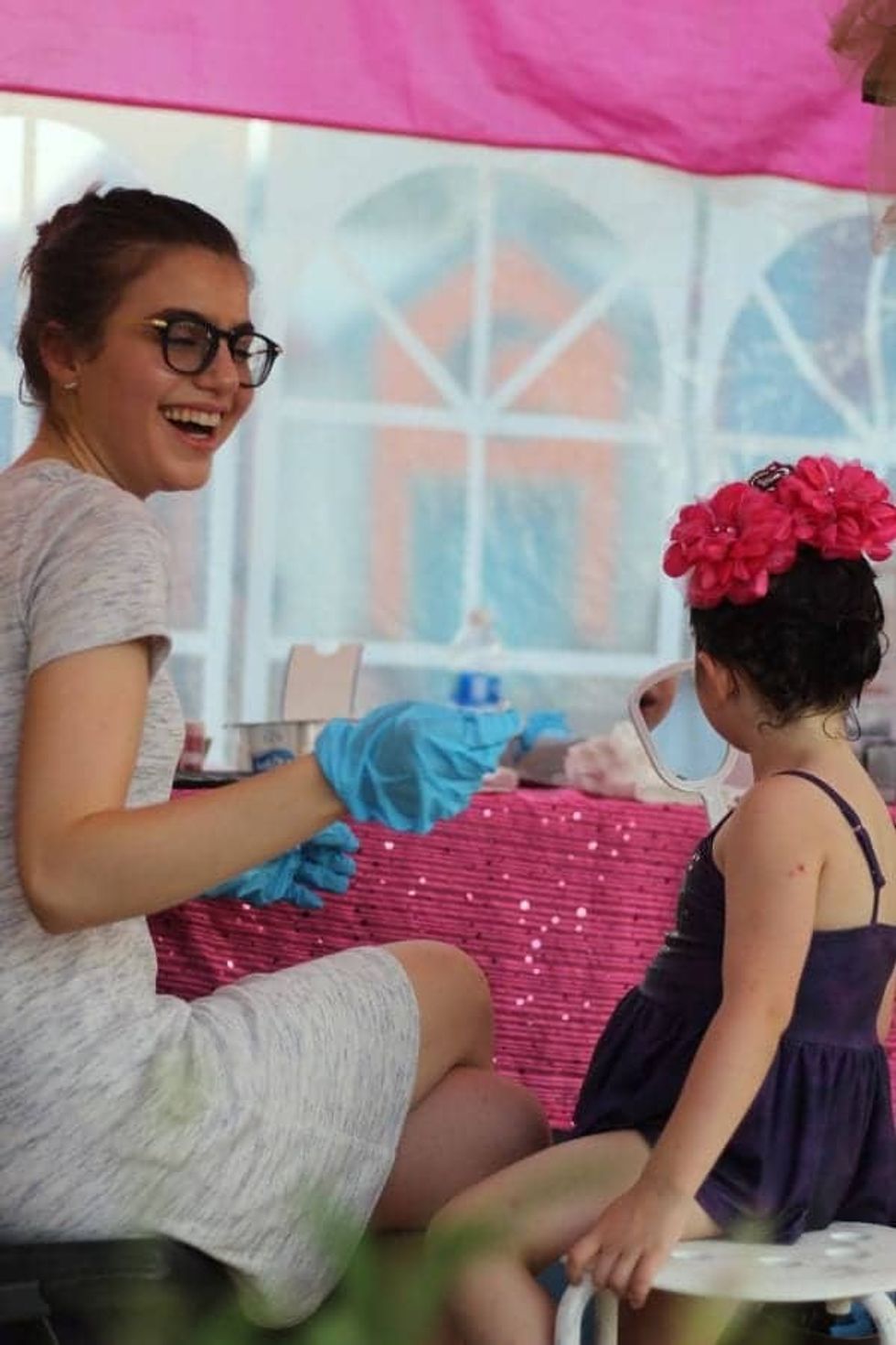 Sami Gayle applying makeup for a young girl's makeover at Give Kids The World