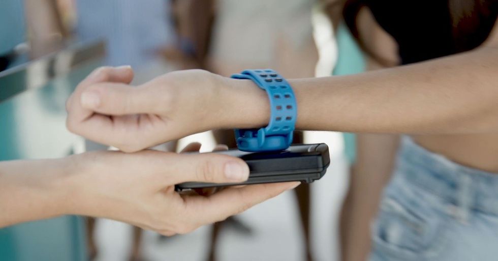 Scanning a blue wristband with a handheld device in an outdoor setting