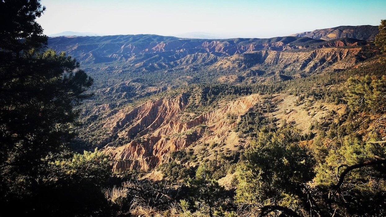 Scenic view of rugged mountains and valleys under a clear blue sky.