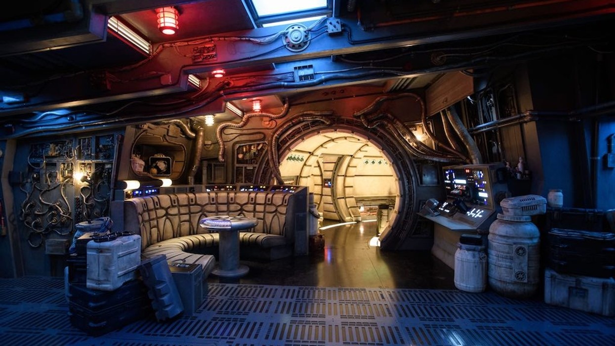 Sci-fi spaceship interior with round door, control panels, and curved seating area.