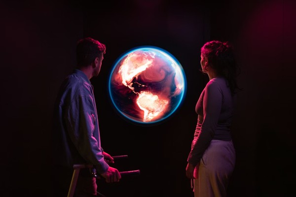Science Museum Group - YOU:MATTER. Two people gaze at an illuminated globe in a dark, ambient setting.