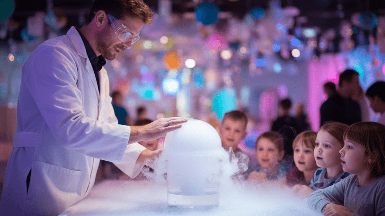 Scientist performs dry ice experiment for captivated children in colorful science lab.