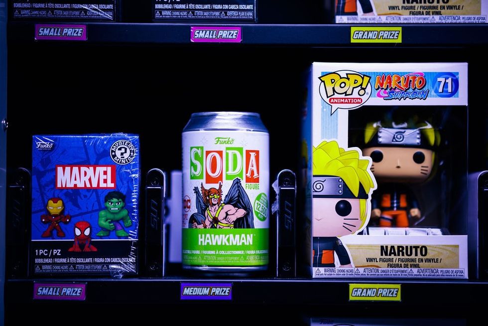 Shelves displaying Marvel pack, Hawkman soda, and Naruto figurine.