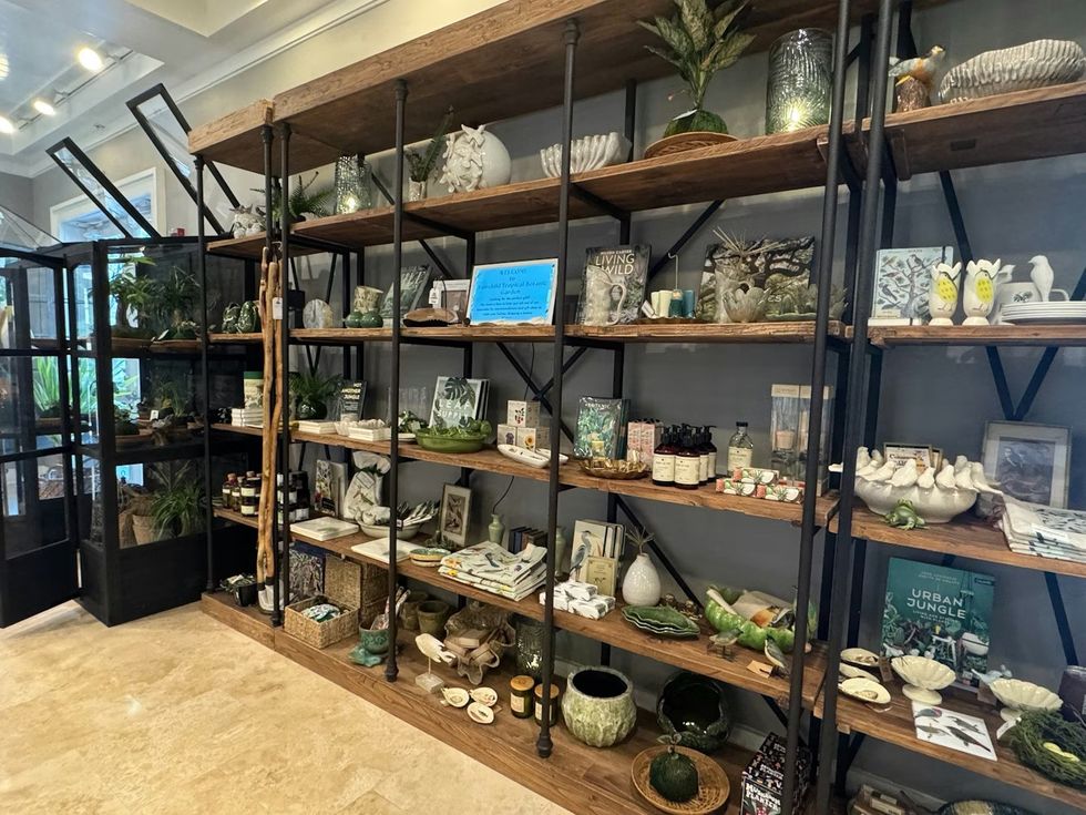 Shelves displaying various home decor items and books in a well-lit interior store. The Sanctuary Shop at Fairchild Tropical Botanic Garden
