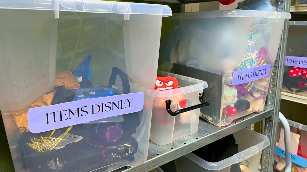 Shelves with labeled bins containing assorted items and toys at Disneyland Paris