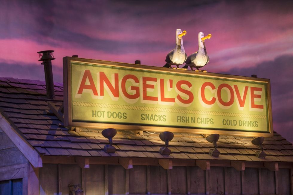 Sign for "Angel's Cove," roof with two seagulls, offers hot dogs and snacks.