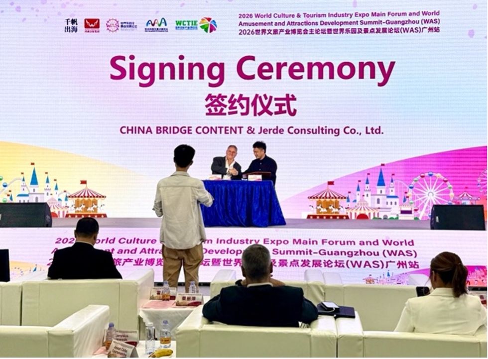 Signing ceremony at AAA 2026 with two men shaking hands on stage - China Bridge Content and Jerde