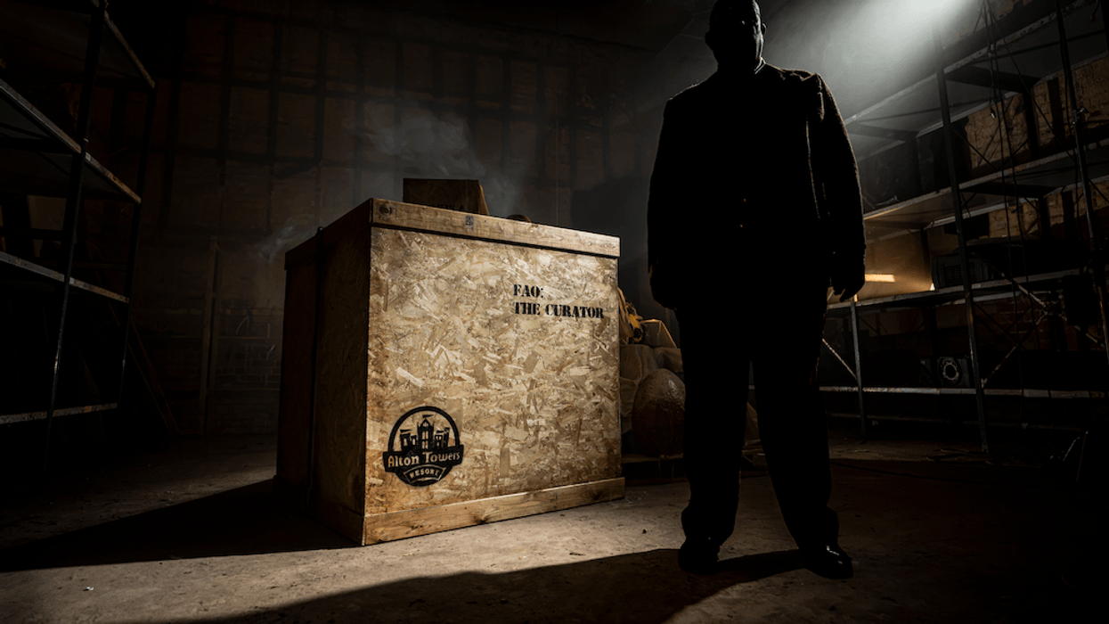 Silhouette of a man next to a large crate with "For the Curator" text in a dimly lit room.