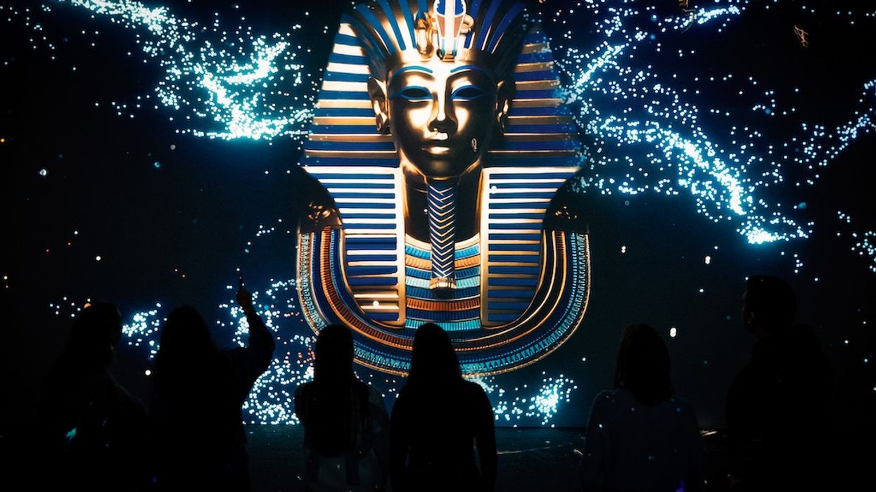 Silhouettes face a digital King Tut mask amidst sparkling stars.