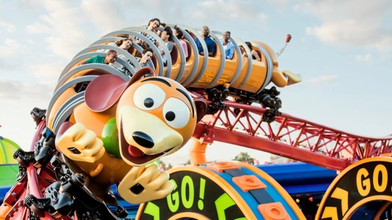 Slinky Dog roller coaster with excited riders on colorful track.