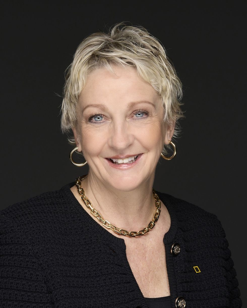 Smiling woman, \u200bJill Tiefenthaler, with short blond hair in a black outfit and gold jewelry.