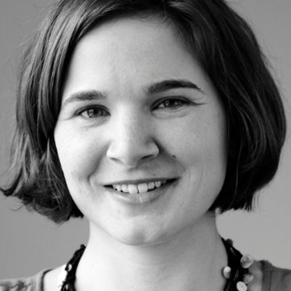 Smiling woman with short hair in a black and white portrait.