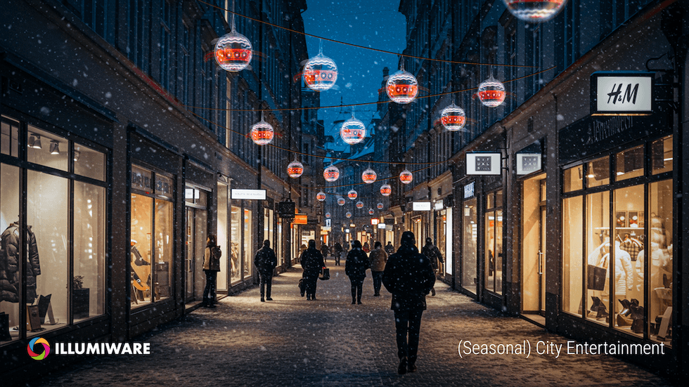 Snowy city street with hanging lanterns and shop windows.