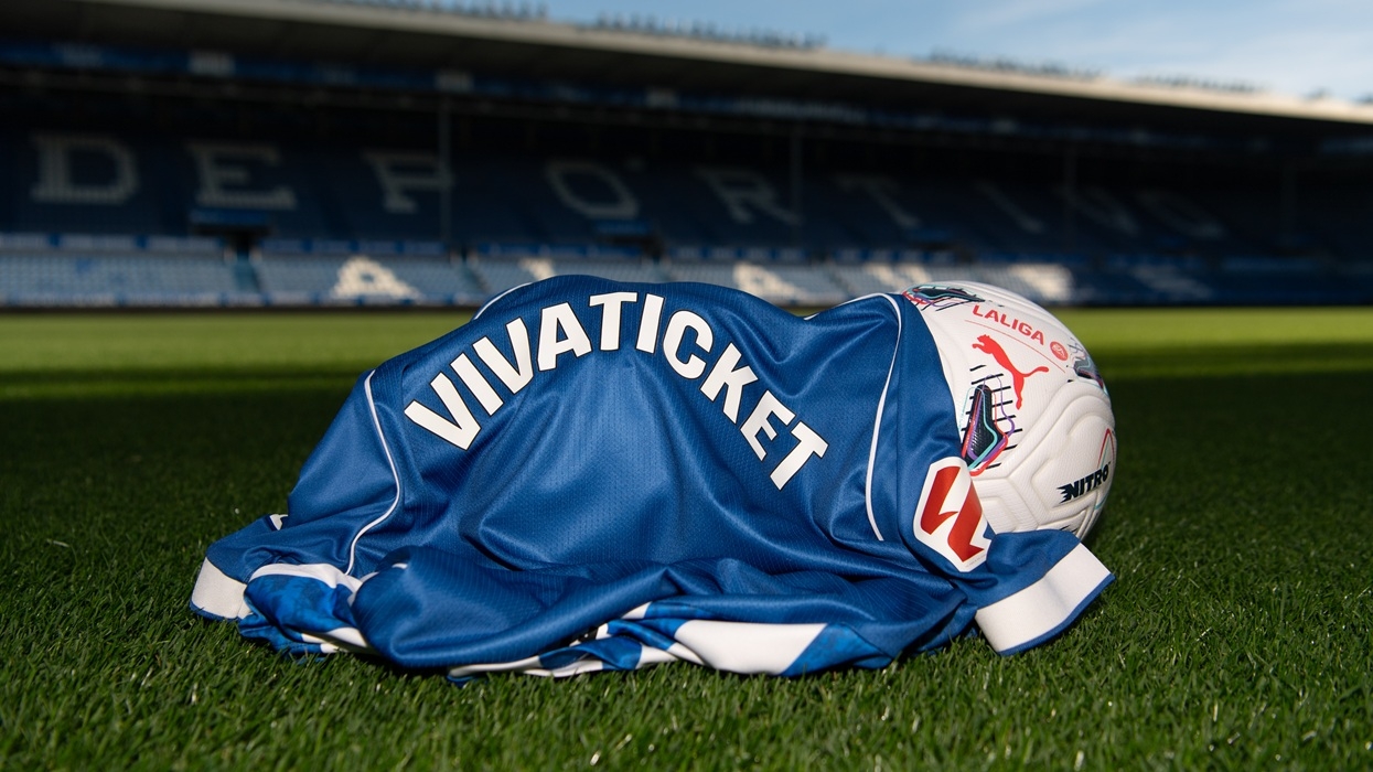 Soccer jersey and ball on grass, stadium background, "VIVATICKET" text visible.