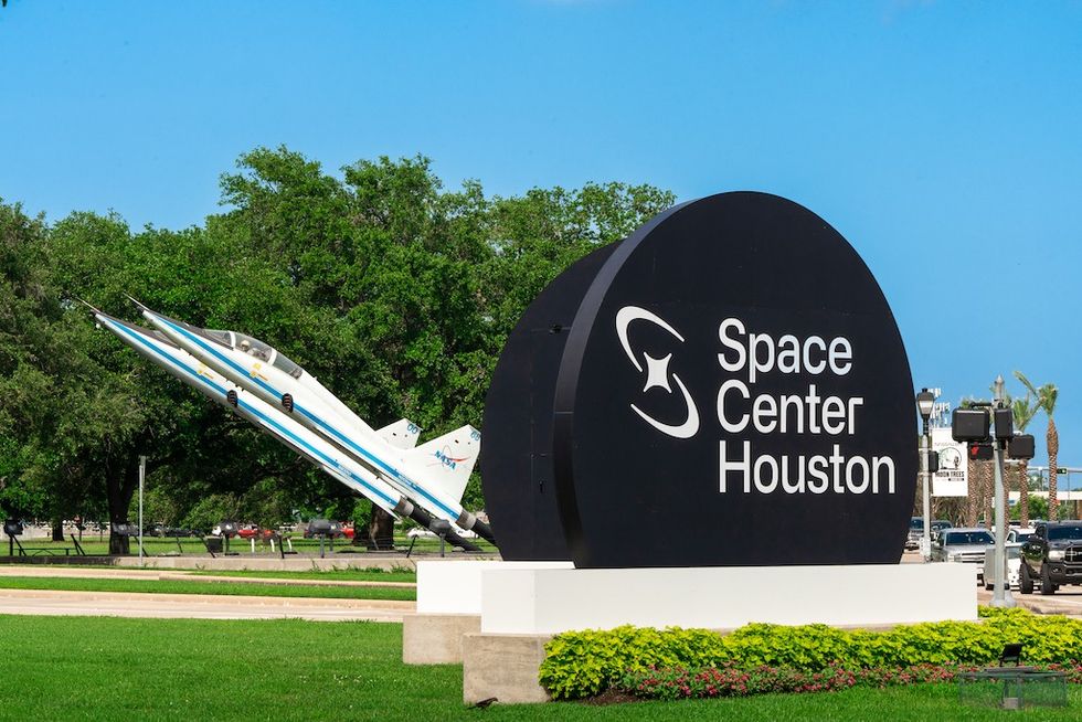 Space Center Houston sign with two display jets in the background.