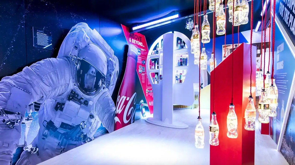 Space-themed room with an astronaut, Coca-Cola display, and bottle-shaped lights.