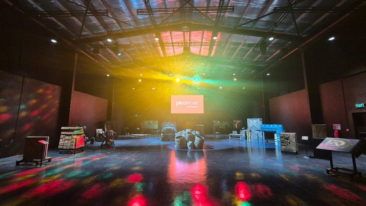 Spacious indoor arena with colorful lights and scattered obstacles.