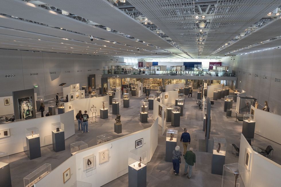 Spacious modern art museum called the Sainsbury Centre interior with visitors and various exhibits on display.