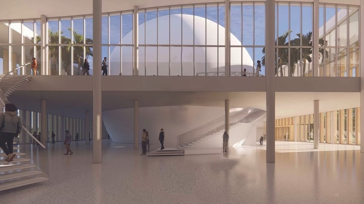 Spacious modern atrium with large windows, stairs, a central dome, and people walking around.
