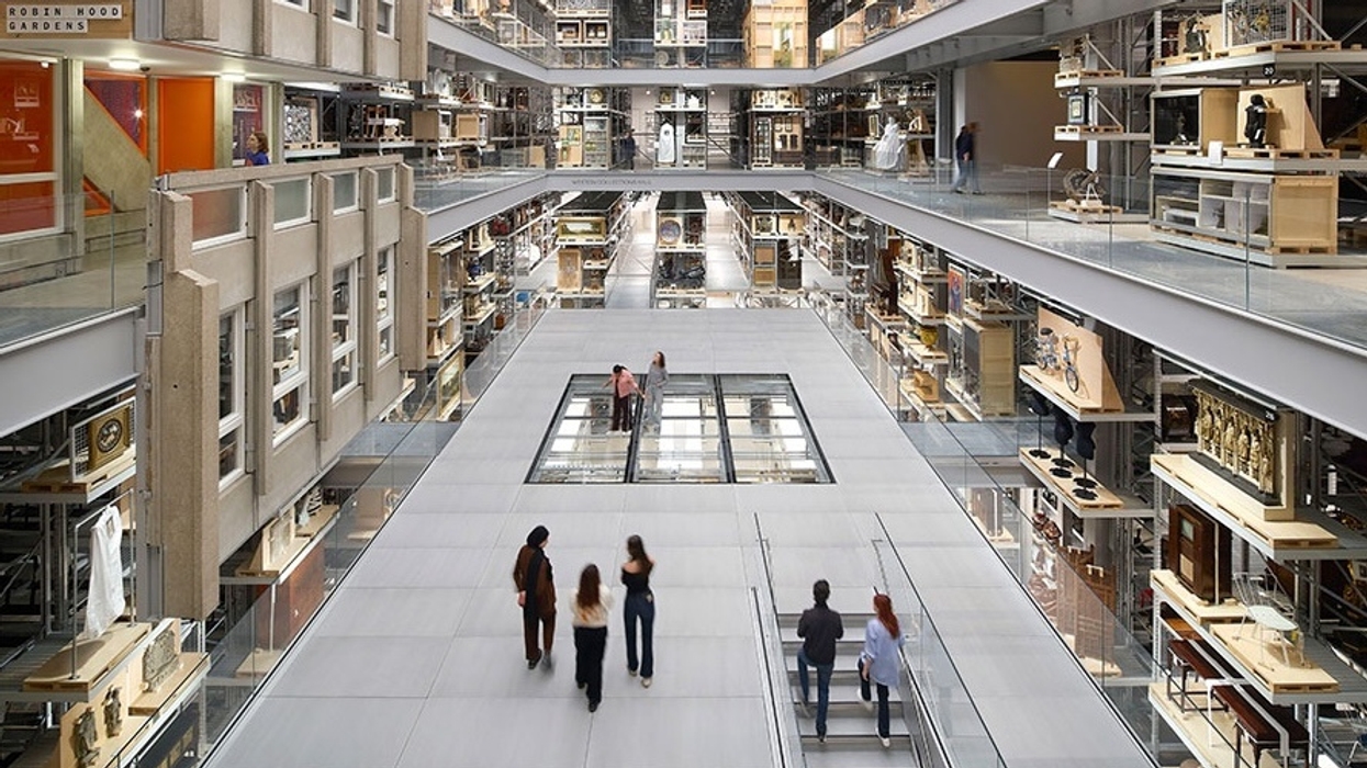 Spacious multilevel atrium at V&A East Storehouse with glass walls and artifacts, people walking on the central walkway.