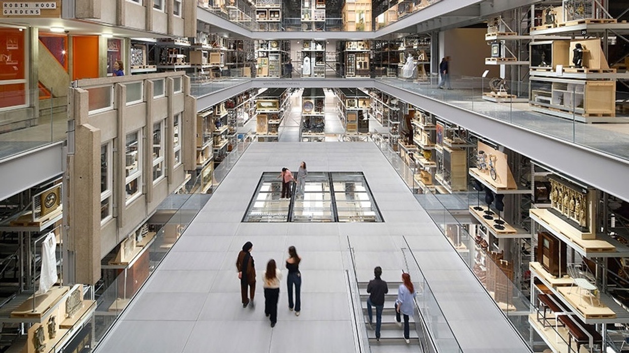Spacious multilevel atrium at V&A East Storehouse with glass walls and artifacts, people walking on the central walkway.