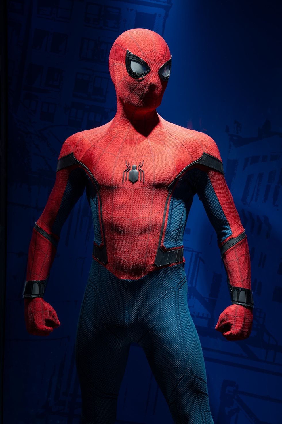 Spider-Man mannequin in a red and blue suit against a dark blue background.