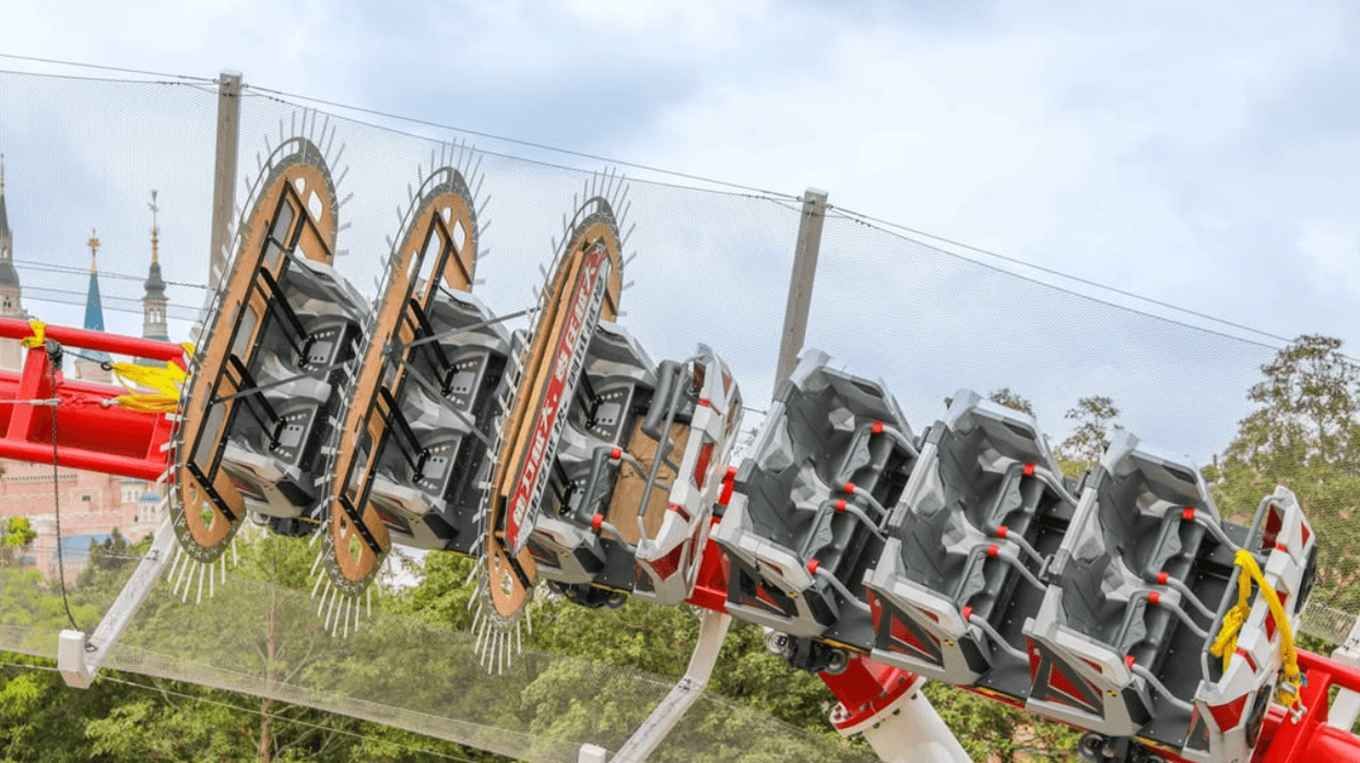 Spider-Man roller coaster with seats on a rotating arm against a cloudy sky at Shanghai Disneyland